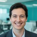 Taslim Felthouse smiling in a modern office setting with contract folders nearby